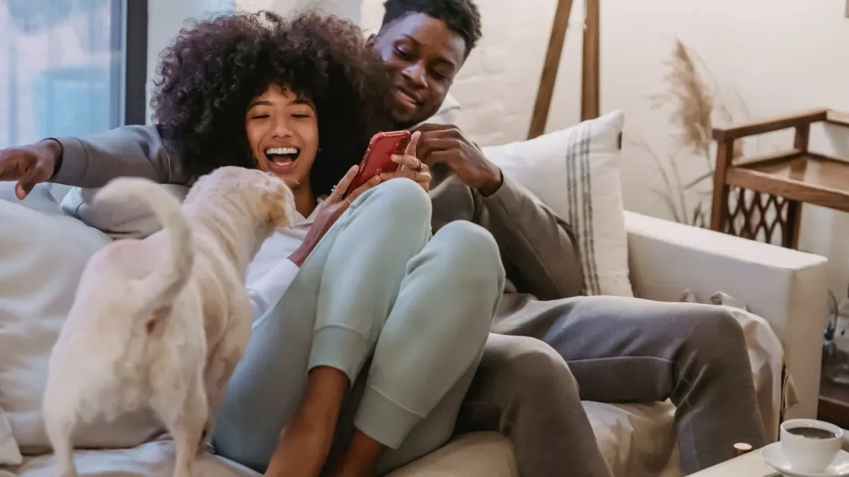 Owner petting dog on sofa